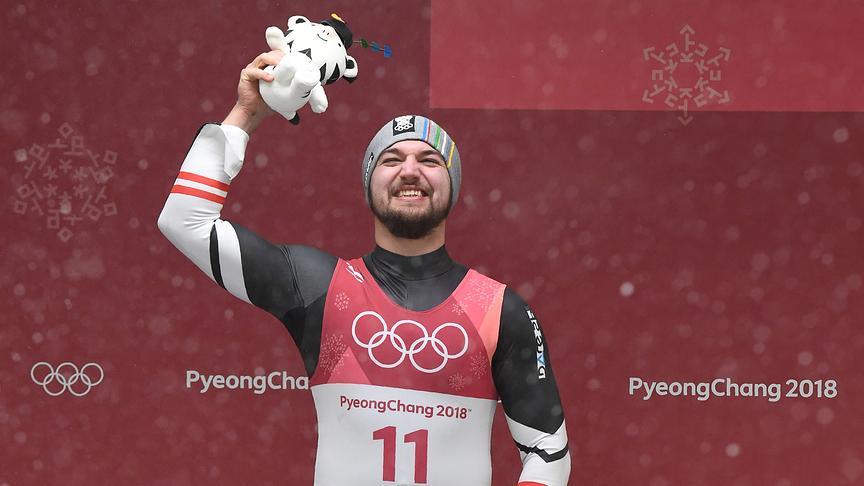 Gold medallist Austria's David Gleirscher celebrates on the podium during the victory ceremony in the men's luge singles during the Pyeongchang 2018 Winter Olympic Games, at the Olympic Sliding Centre on February 11, 2018 in Pyeongchang.