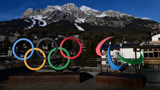 © APA/AFP/Stefano RELLANDINI Die Olympischen und Paralympischen Ringe stehen vor einer eindrucksvollen Bergkulisse in Cortina d'Ampezzo.