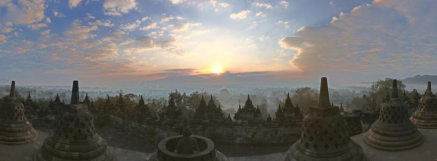Borobudur (auch Borobodur), die größte buddhistische Tempelanlage der Welt, liegt unter einem farbenprächtigen Sonnenaufgangshimmel.