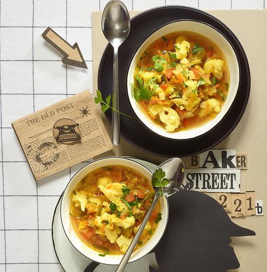 © Stephanie Golser „Die magische Krautsuppe“: Zwei Schüsseln der Krautsuppe stehen dekorativ auf einem gedeckten Tisch im Sherlock-Holmes-Stil.