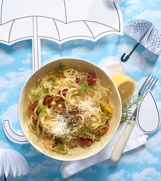 © Stephanie Golser Linguine mit geschmorten Zwiebeln, Fenchel, Ofen-Kirschtomaten & Spirulina sind dekorativ in einer Schale auf einem hellen, grafischen Hintergrund angerichtet.