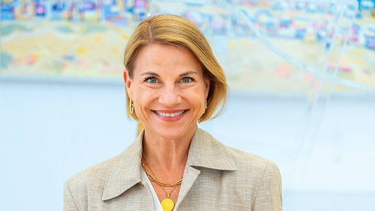Die elegant gekleidete Kristina Sprenger posiert in einem hellen Raum.
