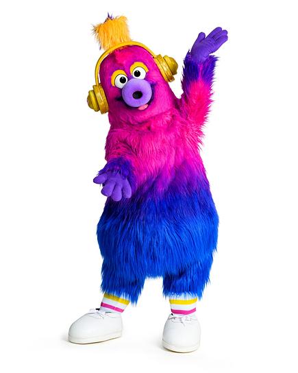 AURI, das offizielle Maskottchen des Eurovision Song Contest 2026, in Pink und Blau trägt goldene Kopfhörer, ein Herz auf der Brust und winkt mit erhobenem Arm.