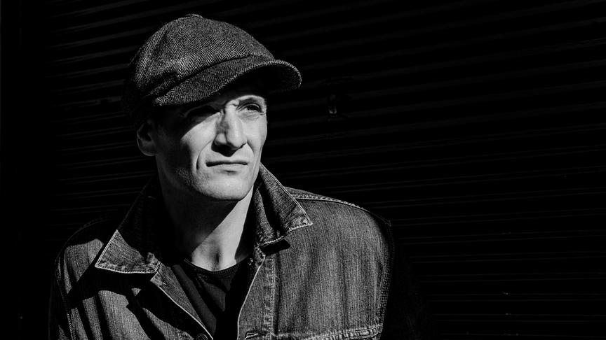 Schwarz-Weiß-Porträt von Drew Sarich mit Schirmmütze