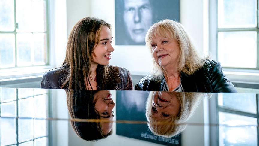 © ORF/E&A Film/Petro Domenigg Mara Romei und Marianne Mendt gemeinsam am Klavier, im Hintergrund ein Bild von Georg Danzer