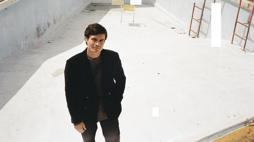 Cellist Lukas Lauermann posiert in einem ausgelassenen Pool