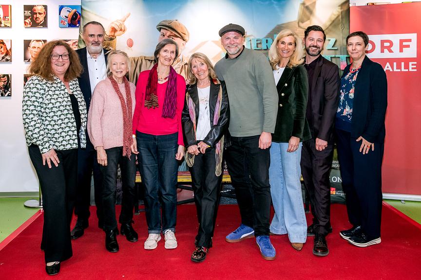 Gruppenfot mit ORF-Fernsehfilmchefin Katharina Schenk, Landeshauptmann Hans Peter Doskozil, Erika Mottl, Linde Prelog, Erika Deutinger, Thomas Stipsits, Producerin Gudula von Eysmondt, Regisseur Daniel Geronimo Prochaska und Susanne Spellitz vor dem Plakat zum „Eierkratz-Komplott“