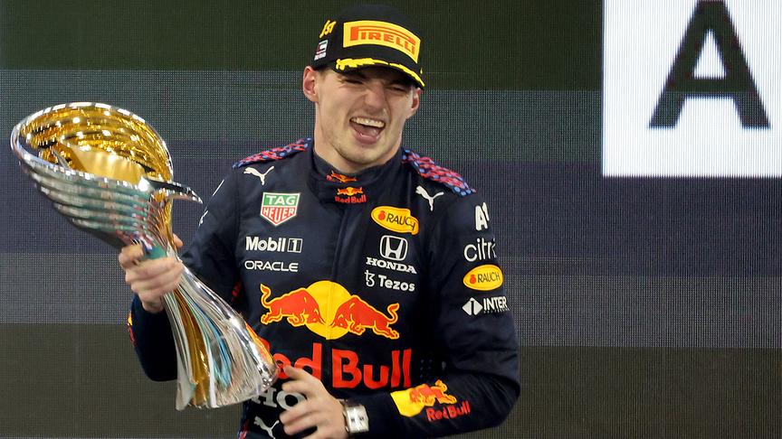 © APA/AFP/Giuseppe CACACE 2021 FIA Formula One World Champion Red Bull's Dutch driver Max Verstappen celebrates on the podium of the Yas Marina Circuit after winning the Abu Dhabi Formula One Grand Prix on December 12, 2021. Max Verstappen became the first Dutchman ever to win the Formula One world championship title when he won a dramatic season-ending Abu Dhabi Grand Prix.