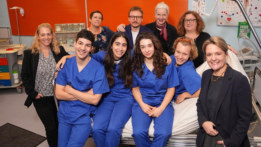 © ORF/Roman Zach-Kiesling Gruppenfoto mit Sabine Renner-Lehner, Marko Kerezovic, Susanne Spellitz, Elif Duygu, Regisseur Michael Podogil, Annalena Hochgruber, Produzentin Viktoria Salcher, Nils Arztmann, ORF-Fernsehfilmchefin Katharina Schenk und ORF-Programmdirektorin Stefanie Groiss-Horowitz am ORF-Serien-Set „Pflegeleicht“