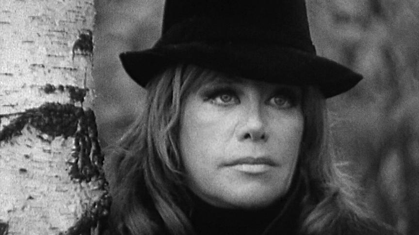 © ORF/zero one film/Bavaria Media Hildegard Knef mit Hut steht im Freien neben einem Birkenstamm in einer schwarz‑weißen Aufnahme.