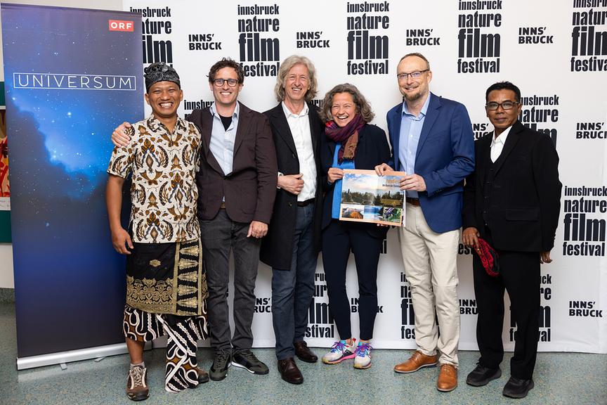 Gruppenfoto mit Oka Dwi Prihatmoko (Produktionsassistent Java) Filmemacher Patrick Centurioni, INFF-Festivaldirektor Johannes Kostenzer, Heike Kiesling (Geschäftsführerin Innsbruck Marketing), „Universum“-Chef Gernot Lercher und Rendra Des Kurnia (Leopardenexperte) vor einer Fotowand beim Innsbruck Nature Film Festival