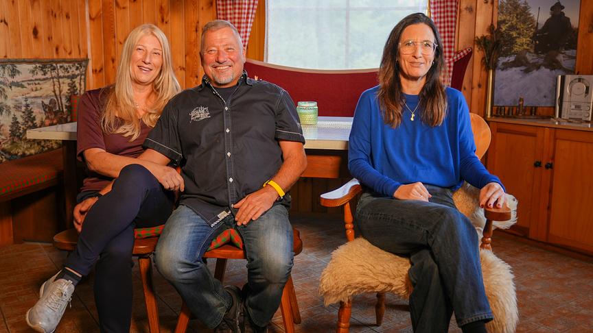 © ORF/Talk TV/Wout Kichler Bea, Klaus und Nina Horrowitz sitzen nebeneinander in einer Bauernstube und lächeln in die Kamera.