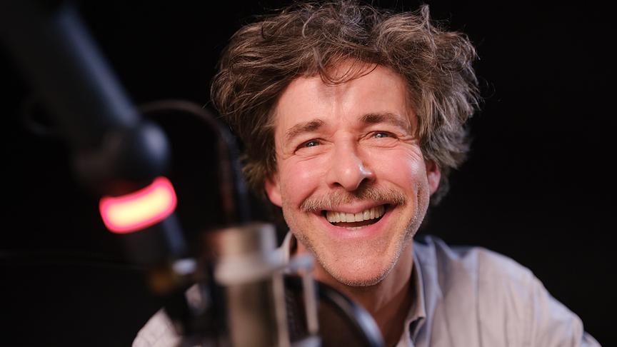© ORF/Ö1/Joseph Schimmer Nahaufnahme von Markus Meyer, der lächelnd in einem Studio vor einem Mikro sitzt
