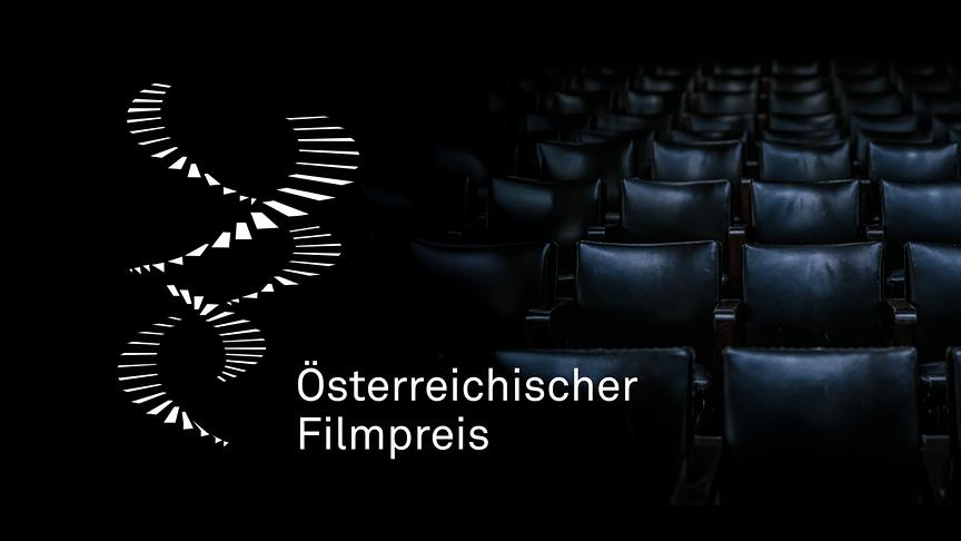 Das Bild zeigt das Logo zum Österreichischen Filmpreis vor einer dunklen, leeren Kinosaal‑Kulisse mit schwarzen Ledersesseln.