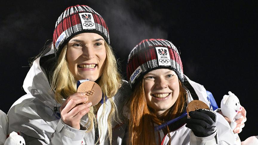 Die österreichischen Rodlerinnen Selina Egle und Lara Kipp halten strahlend ihre Bronzemedaillen im Rahmen der Siegerehrung im Frauen Doppelsitzer-Bewerb im Sliding Center in Cortina d'Ampezzo.