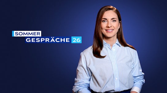 Simone Stribl steht vor einem dunkelblauen Studiohintergrund, neben ihr der Schriftzug „Sommergespräche 26“