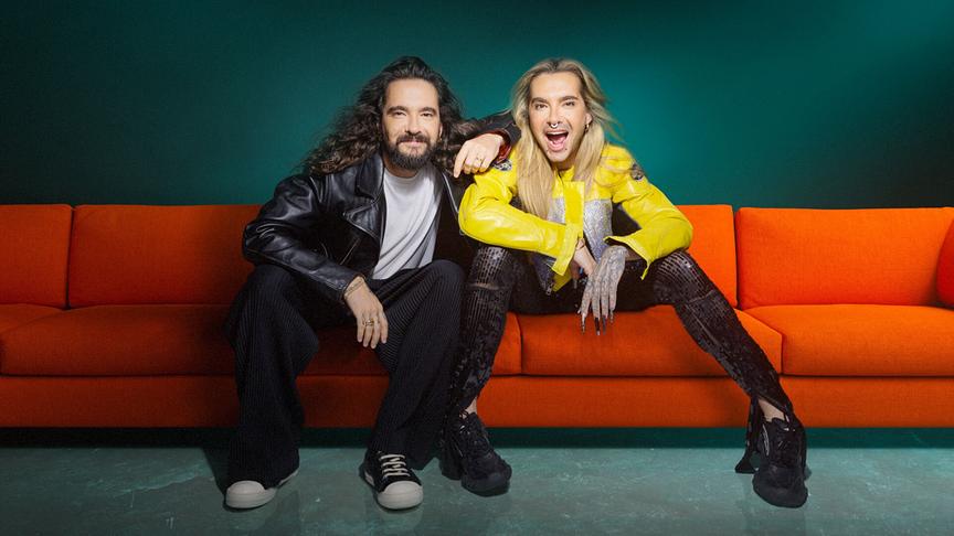 © ORF/ZDF/Rankin/Serviceplan München Tom und Bill Kaulitz in auffälliger, modischer Kleidung sitzen cool auf einem roten Sofa