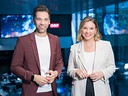 Philipp Maschl und Kathrin Pollak stehen lächelnd nebeneinander im ORF-Newsroom